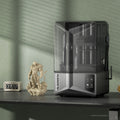 ELEGOO Saturn 4 Ultra, impresora 3D de resina 12K junto a una figura impresa