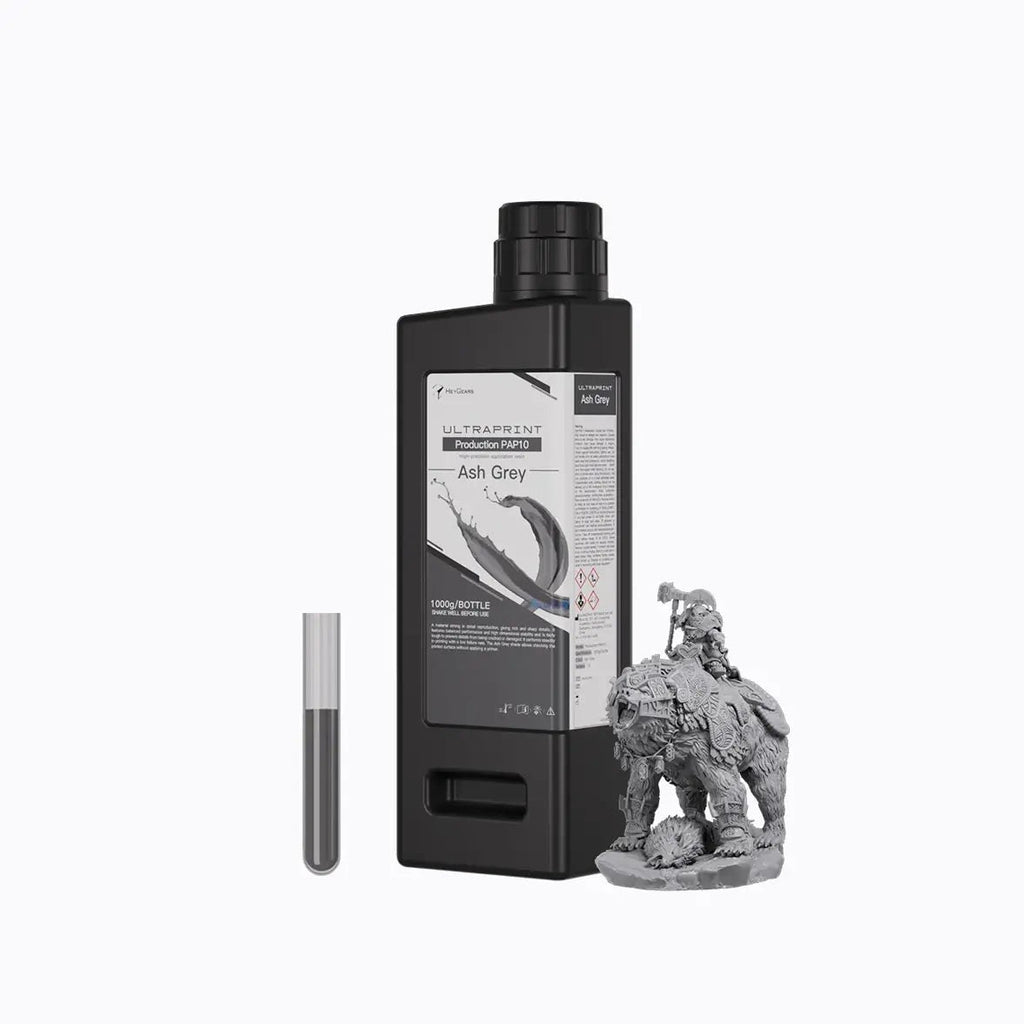 Botella de 1 kg de resina HeyGears UltraPrint PAP10 gris ceniza junto a una miniatura impresa